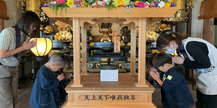 お祈りをする幼稚園生と教員